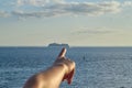 Cruise on ship hand points to cruise liner on horizon Royalty Free Stock Photo