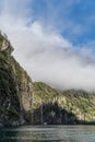 Cruise ship in Milford sound beneath waterfall Royalty Free Stock Photo