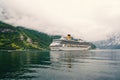 Cruise ship in norwegian fjord. Passenger liner docked in port. Travel destination, tourism. Adventure, discovery Royalty Free Stock Photo