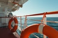 On a cruise ship, an orange lifebuoy is sheltered under an awning