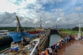 A cruise ship with the passengers on the bow watching ships going through the Panama Canal Royalty Free Stock Photo