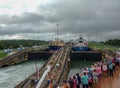 A cruise ship with the passengers on the bow watching a the water being raise  on the first lock in the Panama Canal Royalty Free Stock Photo