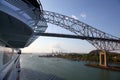 Cruise ship passing under the Bridge of the Americas, with a major shipping port in the background, Panama Canal Royalty Free Stock Photo