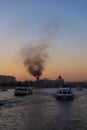 Cruise ship sails on the Moskva river. Fire and smoke in the city centre of Moscow.