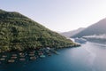 Cruise ship sails on the sea past an oyster farm at the foot of the mountains. Drone Royalty Free Stock Photo