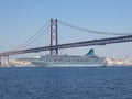 A cruise ship sails under the bridge of April 25 in Lisbon, Portugal, Europe Royalty Free Stock Photo