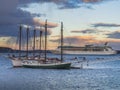 Cruise ship and schooners at sunset