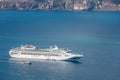 Cruise ship in the sea near the volcano of Santorini island, Greece. Beautiful tourism and travel transportation Royalty Free Stock Photo