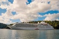 Cruise ship at seacoast in Fowey, United Kingdom. Ocean liner in sea on cloudy sky. Summer vacation on tropical island Royalty Free Stock Photo