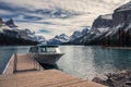 Cruise ship tour anchored on wooden dock with canadian rockies in Spirit Island Royalty Free Stock Photo
