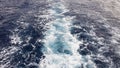 Cruise ship or trail on the surface of the blue red sea. Sea water ship trail with white foamy wave. Top view of the deep ocean. Royalty Free Stock Photo