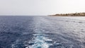 Cruise ship or trail on the surface of the blue red sea. Sea water ship trail with white foamy wave. Top view of the deep ocean. Royalty Free Stock Photo