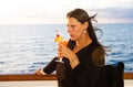 Cruise ship vacation elegant woman drinking fruit cocktail at dinner enjoying sea Royalty Free Stock Photo