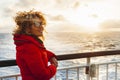 Cruise ship vacation woman enjoying sunset on travel at sea. Traveler happy woman in red jacket looking at ocean relaxing on Royalty Free Stock Photo