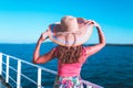 Cruise ship vacation woman enjoying travel vacation at sea. Free carefree happy girl looking at ocean and holding sunhat Royalty Free Stock Photo