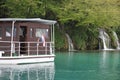 Cruise ship with a waterfall in the background in the Plitvice Lakes National Park Royalty Free Stock Photo