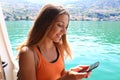 Cruise ship woman using mobile phone on travel vacation. Girl texting sms or using Wifi Internet. Tourist looking at her holidays