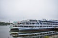 Cruise ships at the river pier, the water surface reflects the retro tourist transport, fog and clouds Royalty Free Stock Photo