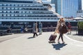 Cruise travel passengers going on board embarking ship with luggage suitcase. Tourist woman with her carry on luggage