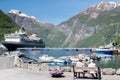 Cruise vessel inside the fjord of Geiranger with snow on the mountain peaks