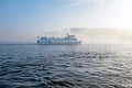 Cruiseboat in the fog in the harbor from Amsterdam the Nethe