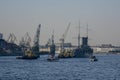 Cruiser Aurora is trailled to ship repair dock surrounded by smaller ships and boats.