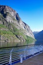 Cruising Geiranger fjord on a beautiful day with views of the Norwegian mountains from the open deck of the ship, Norway.