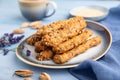 Crumble cookies with seasme and almonds on ceramic plate with cup of coffee on blue wooden background. side view, close up,