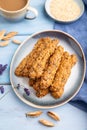 Crumble cookies with seasme and almonds on ceramic plate with cup of coffee on blue wooden background. side view, close up,