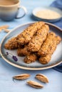 Crumble cookies with seasme and almonds on ceramic plate with cup of coffee on blue wooden background. side view, close up,