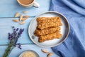 Crumble cookies with seasme and almonds on ceramic plate with cup of coffee on blue wooden background. top view, close up