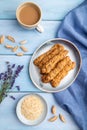 Crumble cookies with seasme and almonds on ceramic plate with cup of coffee on blue wooden background. top view, close up