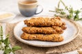 Crumble cookies with seasme and almonds on ceramic plate with cup of green tea on gray concrete background. side view, close up,