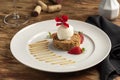 Crumble with ice cream and strawberry, apple on a white plate and blurred background Royalty Free Stock Photo