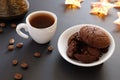 Crumbled chocolate cookies and coffee in small cup on a dark background