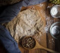 Crumbled granola with a wooden spoon on a brown color them background. Top view