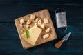 Crumbled Parmesan cheese with basil, a knife, and a grater, a flat lay overhead shot on a wooden background Royalty Free Stock Photo