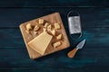 Crumbled Parmesan cheese with a knife and a grater, shot from above on a wooden background Royalty Free Stock Photo