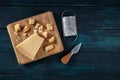 Crumbled Parmesan cheese with a knife and a grater, shot from the top on a dark wooden background Royalty Free Stock Photo