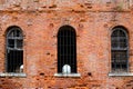 The crumbling brick wall of an old abandoned prison with bars on the windows Royalty Free Stock Photo