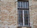 Crumbling brick wall, old window with steel bars Royalty Free Stock Photo