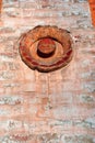 Crumbling red color old brick wall with decoration in shape of circle Royalty Free Stock Photo