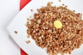 Crumbly buckwheat with butter on white Royalty Free Stock Photo