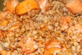 Crumbly buckwheat porridge with sausages. Close-up, surface texture