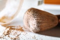 crumbly compact make-up powder in a nude tone with a large powder brush on a white background. Macro, close-up Royalty Free Stock Photo