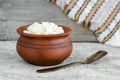 Crumbly homemade cottage cheese in a clay pot