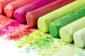 Crumbs and chunks of multicolored chalk, pastels on white paper for watercolor. Yellow, pink, red, green, gray, light green crimso Royalty Free Stock Photo