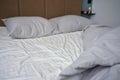 Crumpled bed with pillows, blanket and crumpled sheets in bedroom Royalty Free Stock Photo