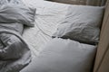 Crumpled bed with pillows, blanket and crumpled sheets in bedroom Royalty Free Stock Photo