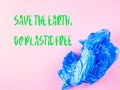 Crumpled blue plastic trash bag on pink background